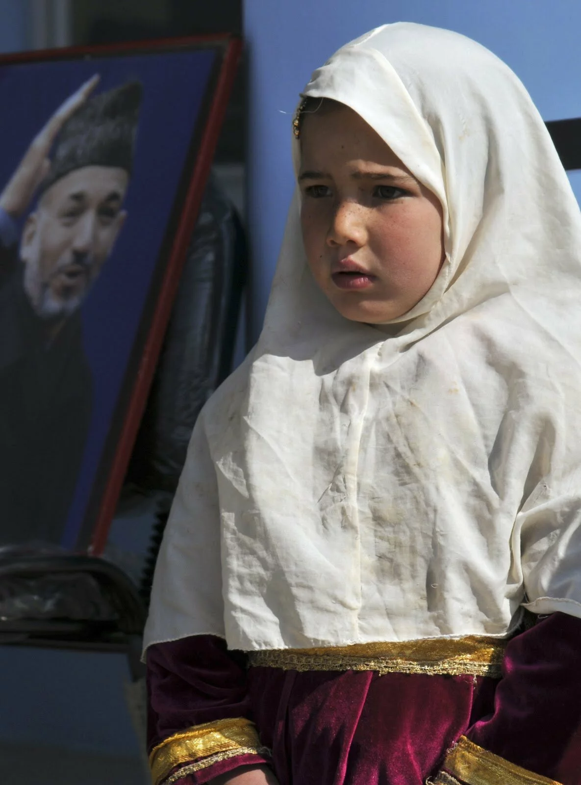 A young Afghan girl stands