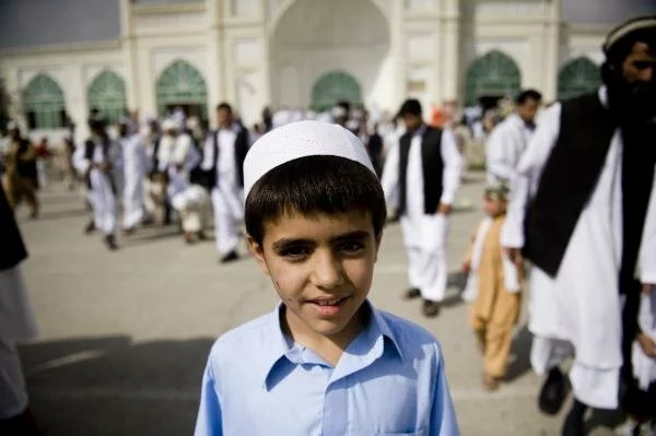 Afghan children walk outside the Eid Gah mosque for Eid al-Fitr prayers in Kabul