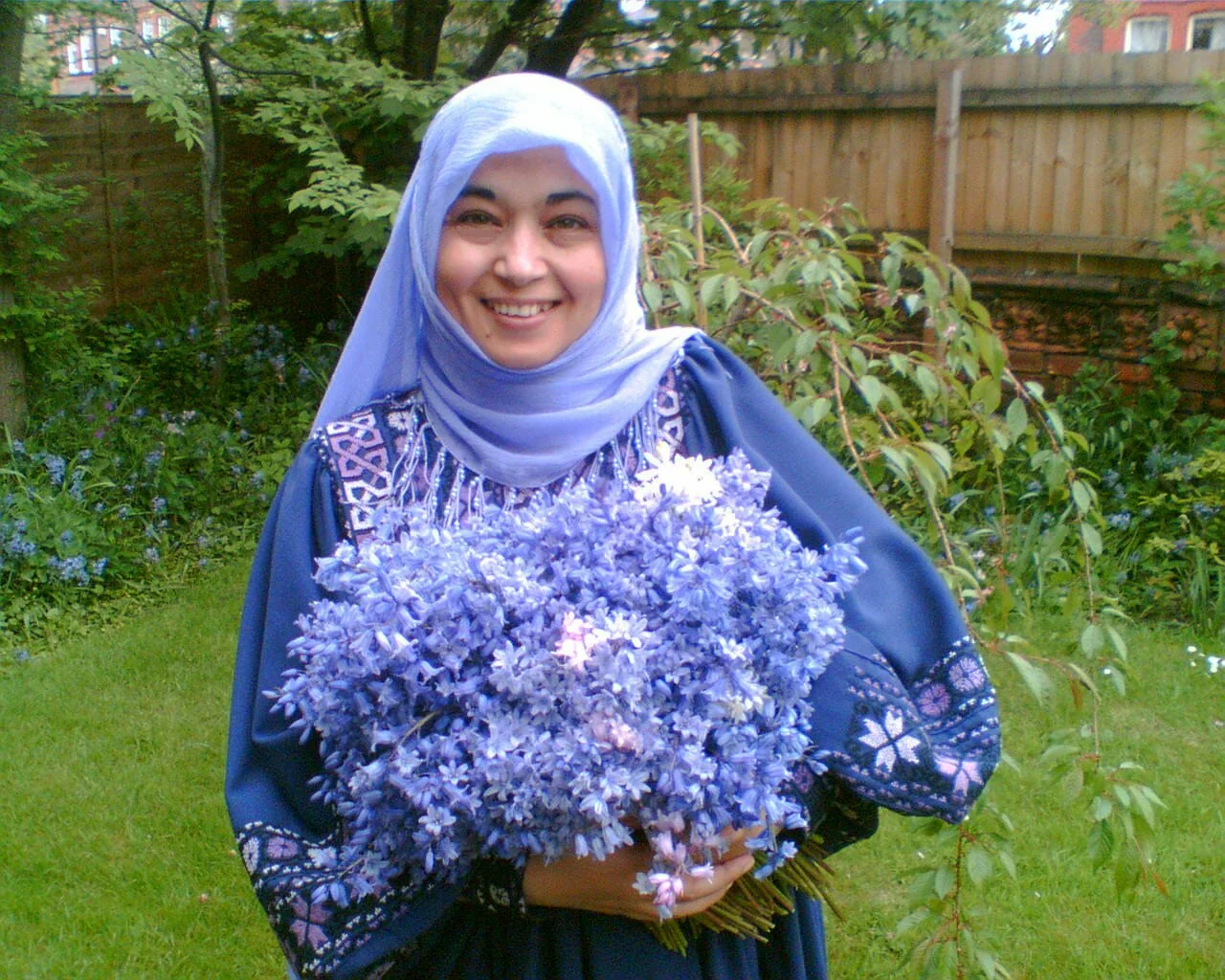 Palestinian women with spary of blue flowers